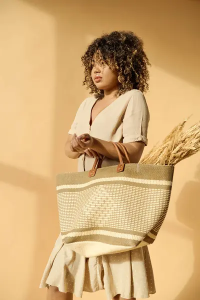 Linda jovem afro-americana com cabelo encaracolado em um vestido de verão segurando uma cesta com uma planta verde vibrante. — Fotografia de Stock
