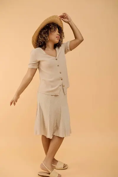Une superbe femme afro-américaine aux cheveux bouclés, vêtue d'une tenue d'été, posant pour une photographie. — Photo de stock