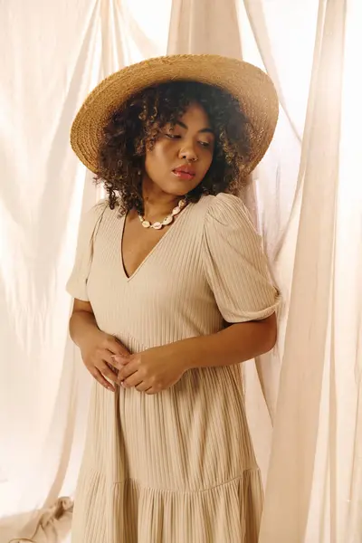 A beautiful young African American woman with curly hair is elegantly dressed in a summer dress and straw hat, exuding grace and style. — Stock Photo