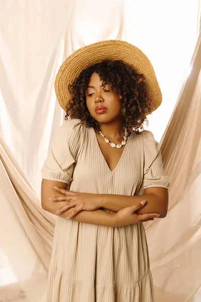 A beautiful young African American woman with curly hair, dressed in a summer outfit, striking a pose in a studio setting. — Stock Photo