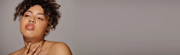 Uma bela jovem afro-americana com cabelo encaracolado posando elegantemente em um estúdio. — Fotografia de Stock