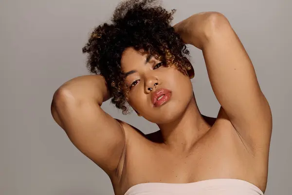 A beautiful young African American woman with curly hair, captured in a mesmerizing close-up shot in a studio setting. — Stock Photo