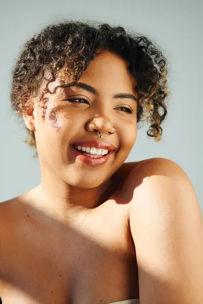 Close-up de uma mulher afro-americana alegre com um cenário vibrante. — Fotografia de Stock