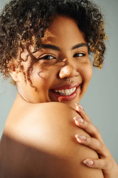Una bella donna afroamericana con un sorriso raggiante su uno sfondo vibrante. — Foto stock