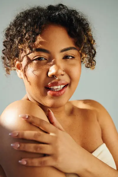 Eine schöne Afroamerikanerin posiert mit einem freudigen Lächeln vor einer lebendigen Kulisse. — Stockfoto