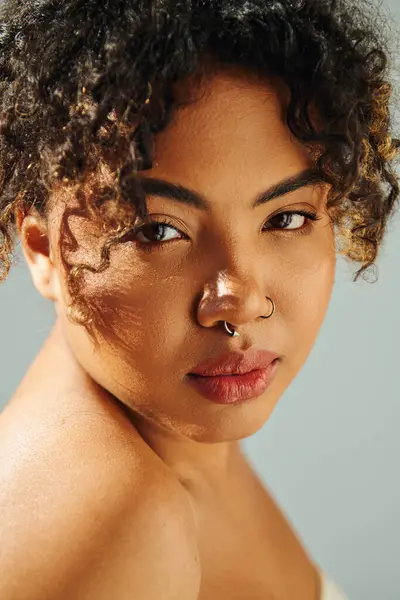 Eine schöne Afroamerikanerin posiert mit einem auffälligen Nasenring vor einer lebendigen Kulisse. — Stockfoto