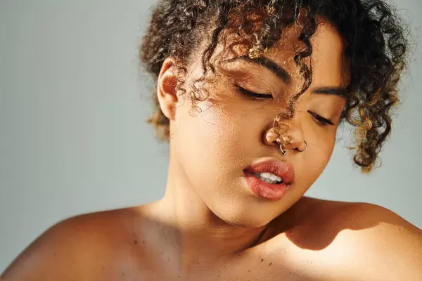 Um close-up de uma bela mulher afro-americana com um anel no nariz marcando uma pose contra um cenário vibrante. — Fotografia de Stock