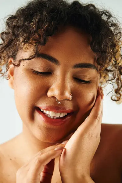 Красивая афроамериканка позирует с кольцом в носу на ярком фоне. — стоковое фото