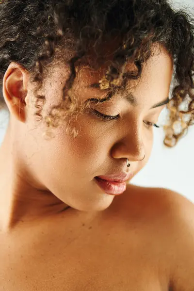 Eine Afroamerikanerin mit lockigem Haar posiert vor einer lebendigen Kulisse. — Stockfoto