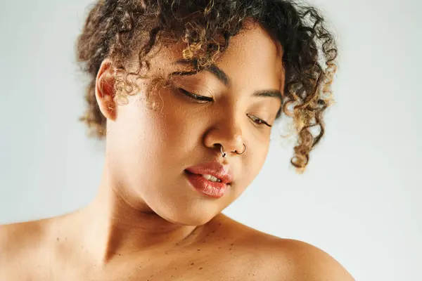 Close-up of an African American woman with curly hair, striking a pose against a vibrant backdrop. — Stock Photo