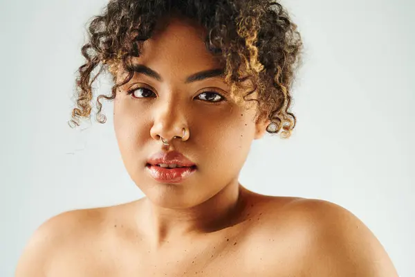 A beautiful African American woman with curly hair striking a pose against a vibrant backdrop. — Stock Photo
