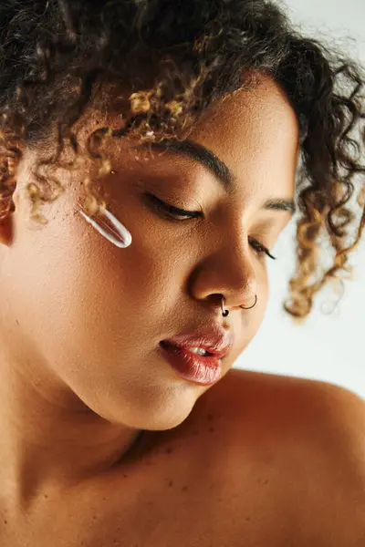 Vue rapprochée d'une femme afro-américaine dynamique arborant un piercing de nez élégant. — Photo de stock