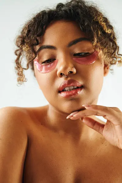 Attractive African American woman showcasing eye patches on a vibrant backdrop. — Stock Photo