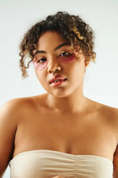 Pretty African American woman showcasing eye patches on a vibrant backdrop. — Stock Photo