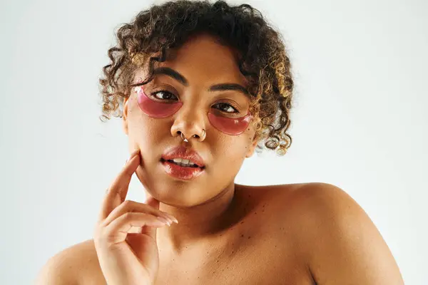 Stylish African American woman showcasing eye patches on a vibrant backdrop. — Stock Photo