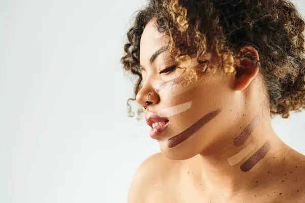 Appealing African American woman with foundation on face poses against vibrant backdrop. — Stock Photo