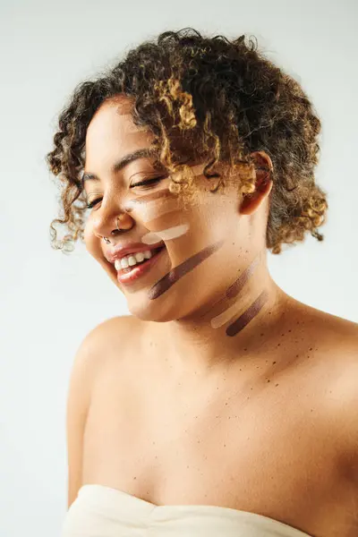 Attraente donna afroamericana con fondazione su pose viso sullo sfondo vibrante. — Foto stock