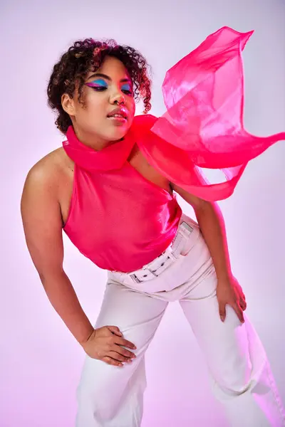 A stylish African American woman posing actively in white pants and a pink top. — Stock Photo