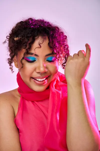A beautiful African American woman striking a pose in a pink scarf and blue eyeshadow. — Stock Photo