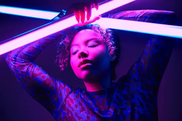 Uma mulher afro-americana ativa segura com confiança uma lâmpada LED brilhante. — Fotografia de Stock
