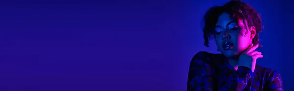 A beautiful African American woman poses gracefully against a vibrant purple backdrop. — Stock Photo