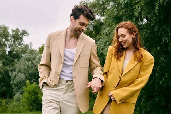 Um homem e uma mulher caminham juntos em um parque verde tranquilo, desfrutando de uma data romântica em um ambiente natural exuberante. — Fotografia de Stock