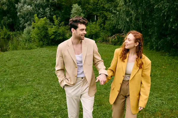 Чоловік і жінка тримаються за руки, ходячи в зеленому полі на романтичному побаченні, оточеному красою природи. — стокове фото