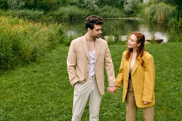 Um casal dá as mãos em meio a um campo, cercado pela beleza da natureza em uma data romântica. — Fotografia de Stock