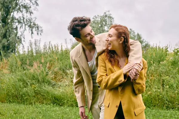 Um homem e uma mulher estão pacificamente em um campo verde exuberante, desfrutando da beleza da natureza ao seu redor.. — Fotografia de Stock