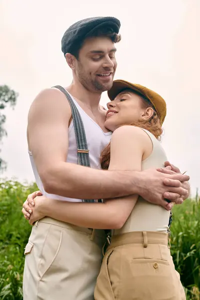 A man and woman lovingly embrace in a lush green field, surrounded by the beauty of nature. — Stock Photo