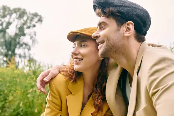 A man and a woman sitting together in a green park, sharing a romantic moment surrounded by nature. — Stock Photo