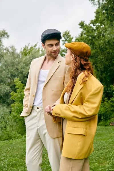 Um homem e uma mulher de pé perto um do outro em um parque verde, exalando uma sensação de tranquilidade e romance. — Fotografia de Stock