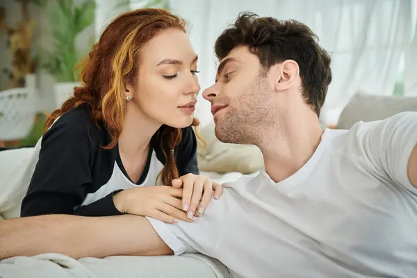 A man and a woman are peacefully reclining together on a cozy bed, enjoying a quiet moment of togetherness. — Stock Photo