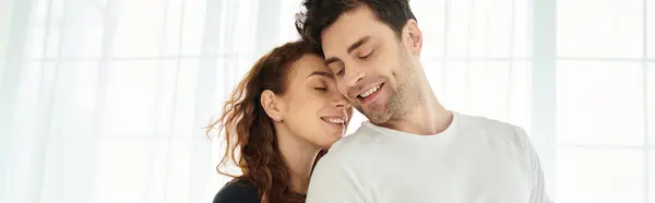 Un uomo e una donna stanno strettamente insieme, condividendo un momento di amore e connessione in un ambiente camera da letto. — Foto stock