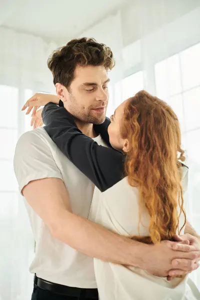 Un hombre y una mujer abrazan fuertemente, sus cuerpos entrelazados en un momento amoroso e íntimo. - foto de stock