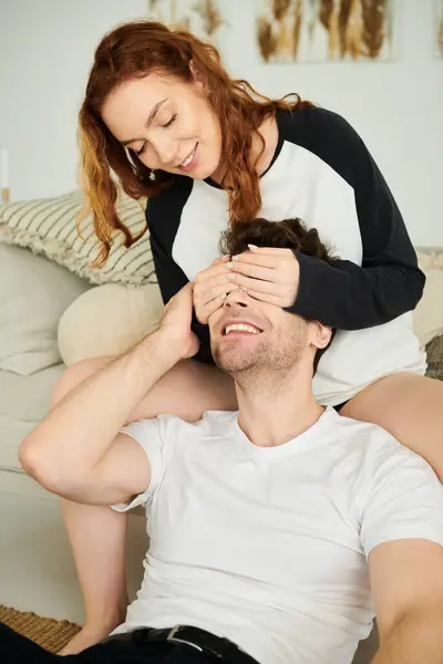 Un uomo e una donna si siedono strettamente insieme su un accogliente divano in un ambiente caldo e intimo. — Foto stock