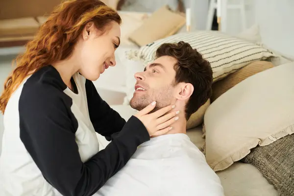 Un uomo e una donna riposano pacificamente su un letto, avvolti tra le braccia, godendo di momenti intimi insieme.. — Foto stock