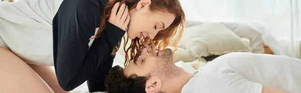 Un homme et une femme se détendent sur un lit douillet, profitant de l'autre compagnie dans un cadre serein chambre. — Photo de stock