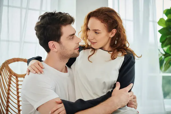 A man and woman tenderly embracing each other, expressing love and closeness in a serene bedroom setting. — Stock Photo