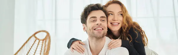 A man tenderly holds a woman in his arms, expressing love and affection in a intimate bedroom setting. — Stock Photo