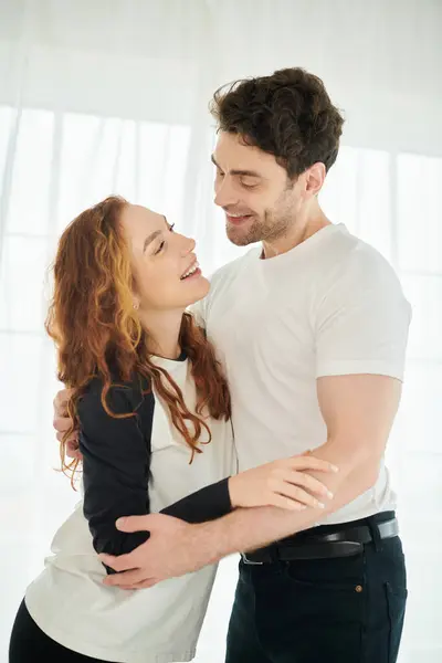 Um homem e uma mulher compartilham um abraço terno em um ambiente de quarto quente e íntimo. — Fotografia de Stock