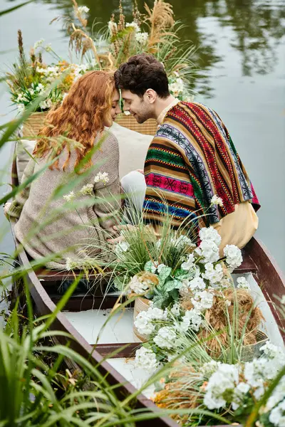 Un uomo e una donna in stile boho si siedono tranquillamente in una barca sull'acqua durante un appuntamento romantico in un lussureggiante parco verde. — Foto stock