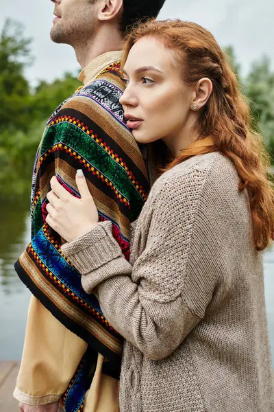 A stylish couple, dressed in boho attire, standing closely together in a lush green park. — Stock Photo