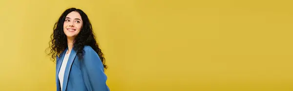 Femme brune aux cheveux bouclés respire la grâce et le style devant un mur jaune vibrant, mettant en valeur une gamme d'émotions. — Photo de stock