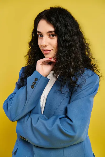 Brunette woman in blue suit showcases elegance and confidence, posing in a studio with a yellow backdrop. — Stock Photo
