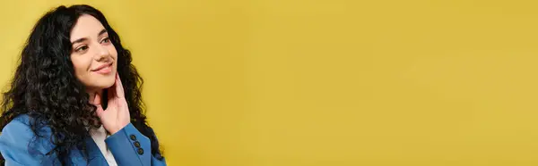 A young, stylish woman with curly hair stands in front of a vibrant yellow wall, showcasing various emotions. — Stock Photo