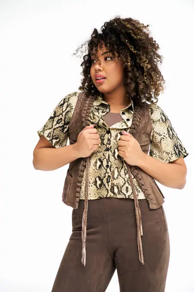 Stylish young african american woman with animalistic print on outfit looking away on white backdrop — Stock Photo