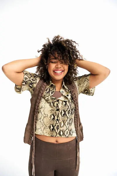 Joyous african american woman in attire with animalistic print acting joyfully on white backdrop — Stock Photo