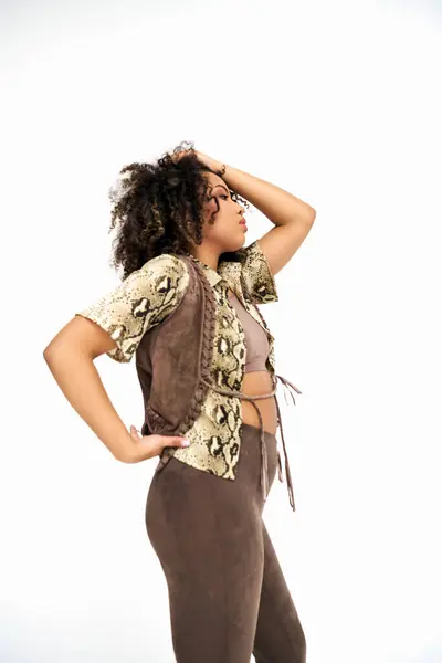 Well dressed african american woman in attire with animalistic print on white backdrop looking away — Stock Photo
