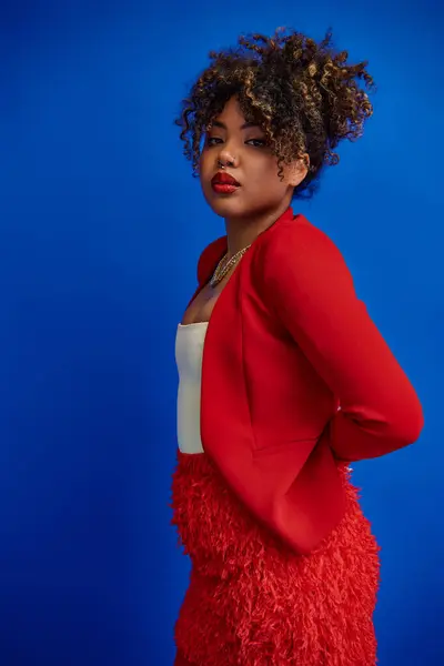 Graciosa atraente mulher afro-americana com cabelo recolhido em traje vibrante olhando para a câmera — Fotografia de Stock